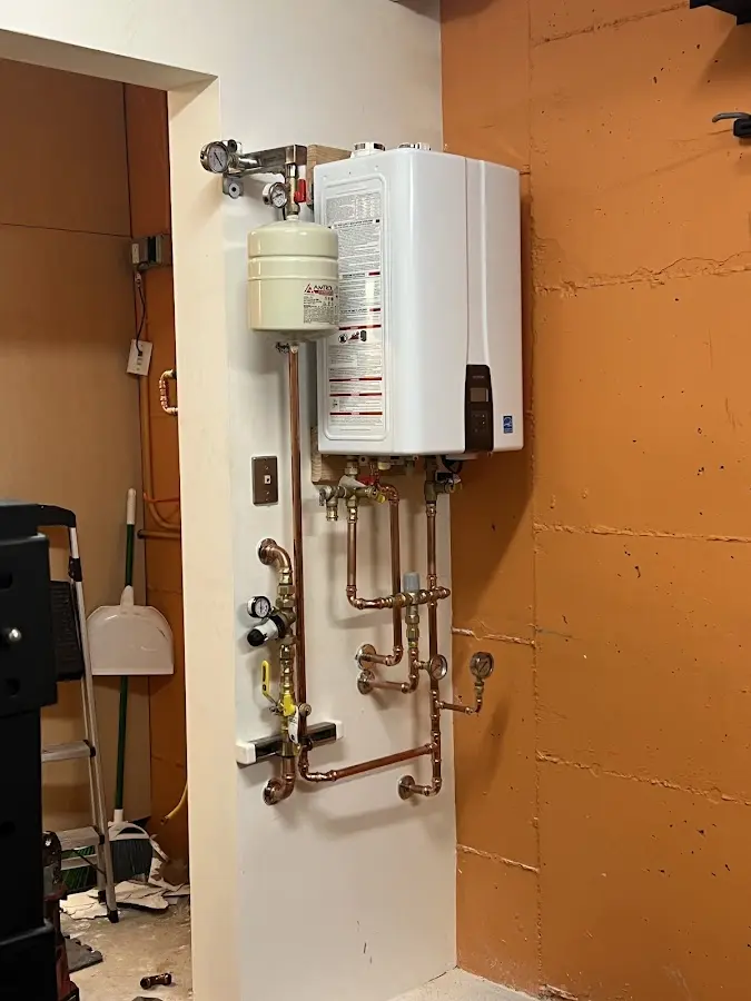 Plumbing technician inspecting water heater connections in Edgewood